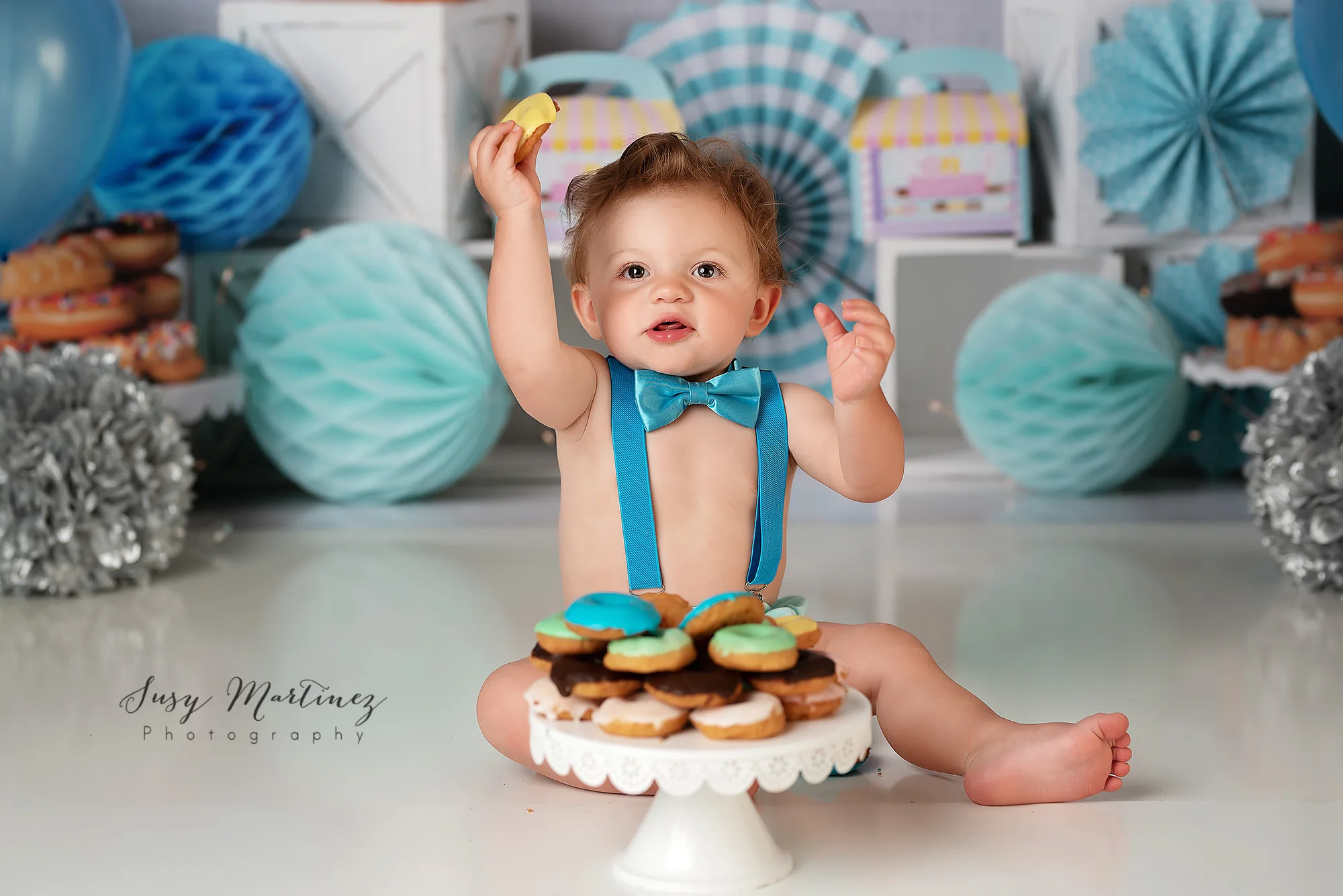 one year old holds up yellow donut during Las Vegas donut smash