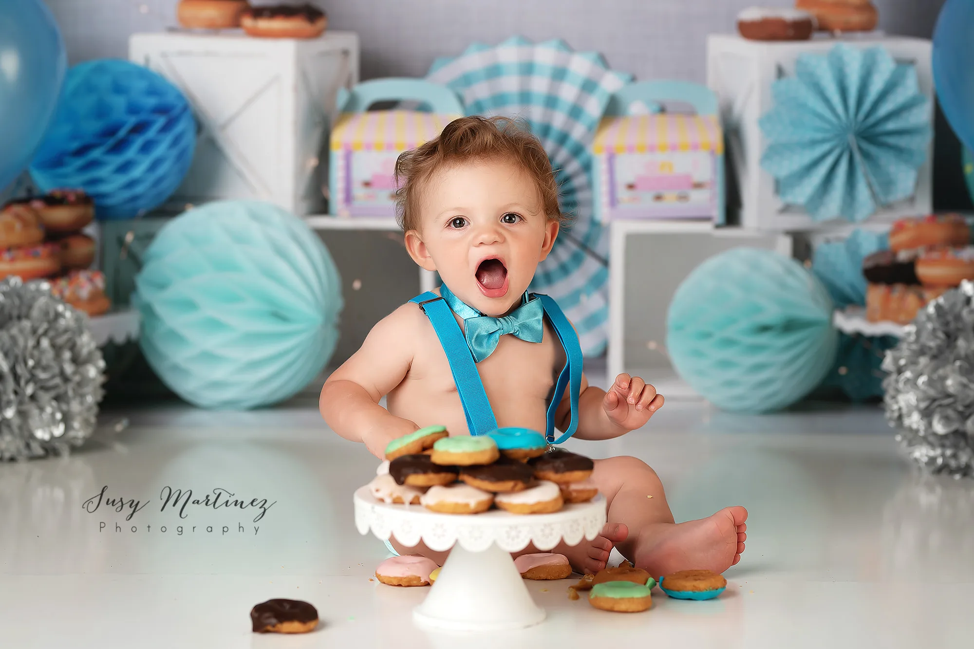 birthday boy in blue suspenders plays with donuts during Las Vegas donut smash