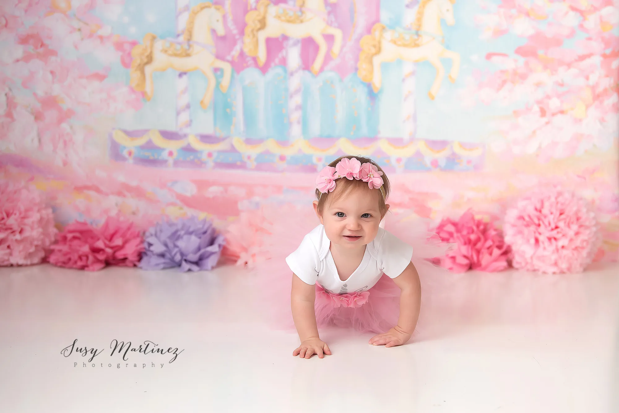 baby girl crawls near carousel drop