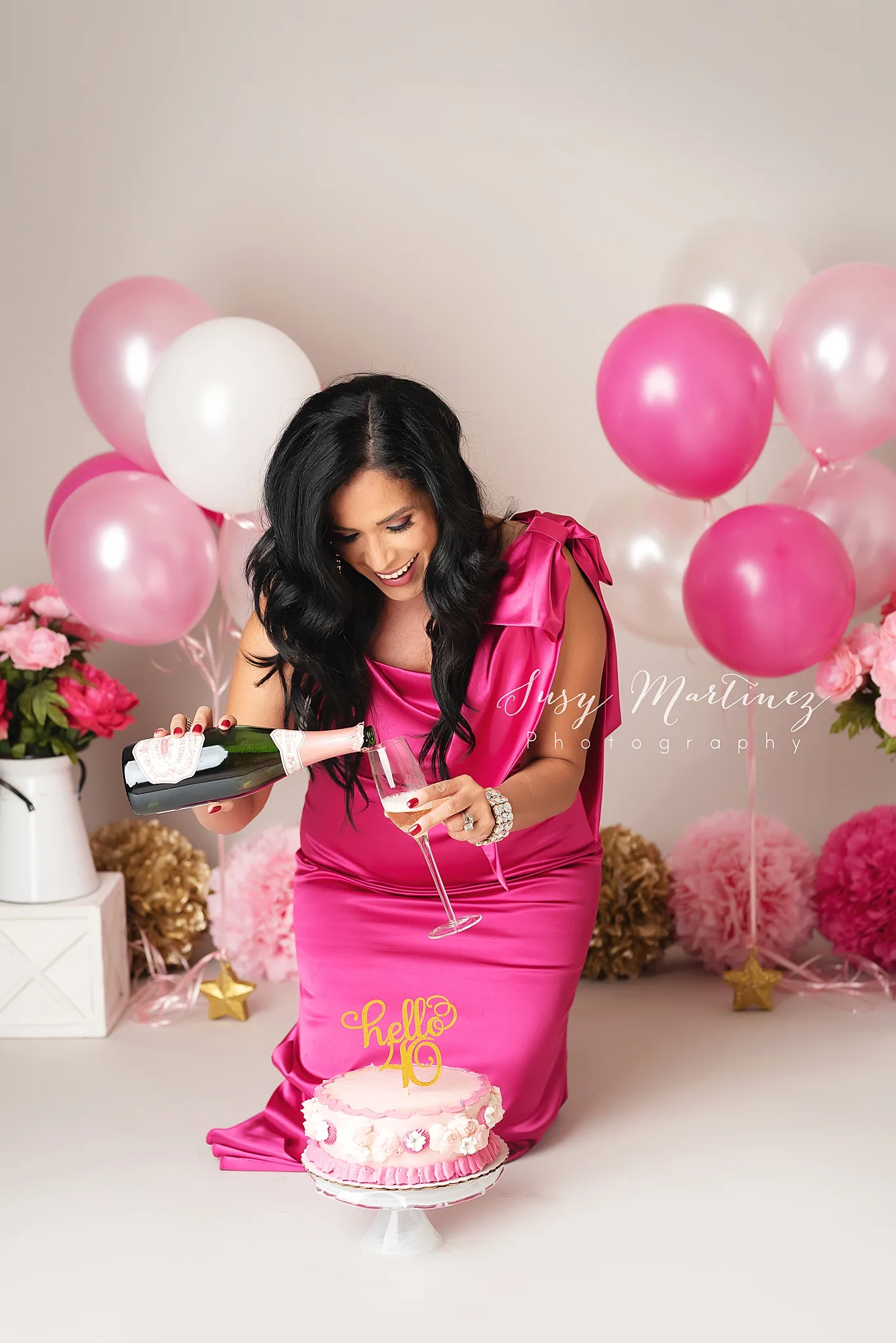 birthday girl pours champagne during adult cake smash