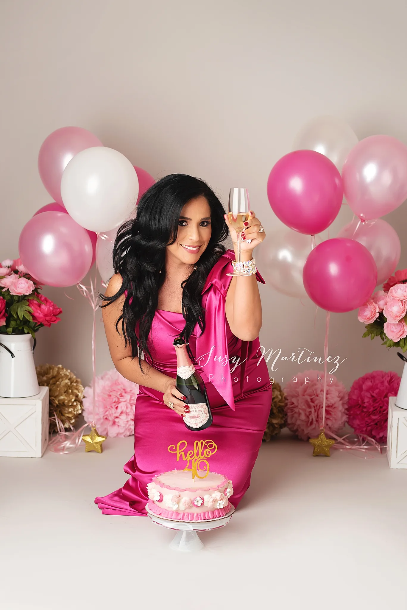 female toasts with champagne during 40th birthday adult cake smash