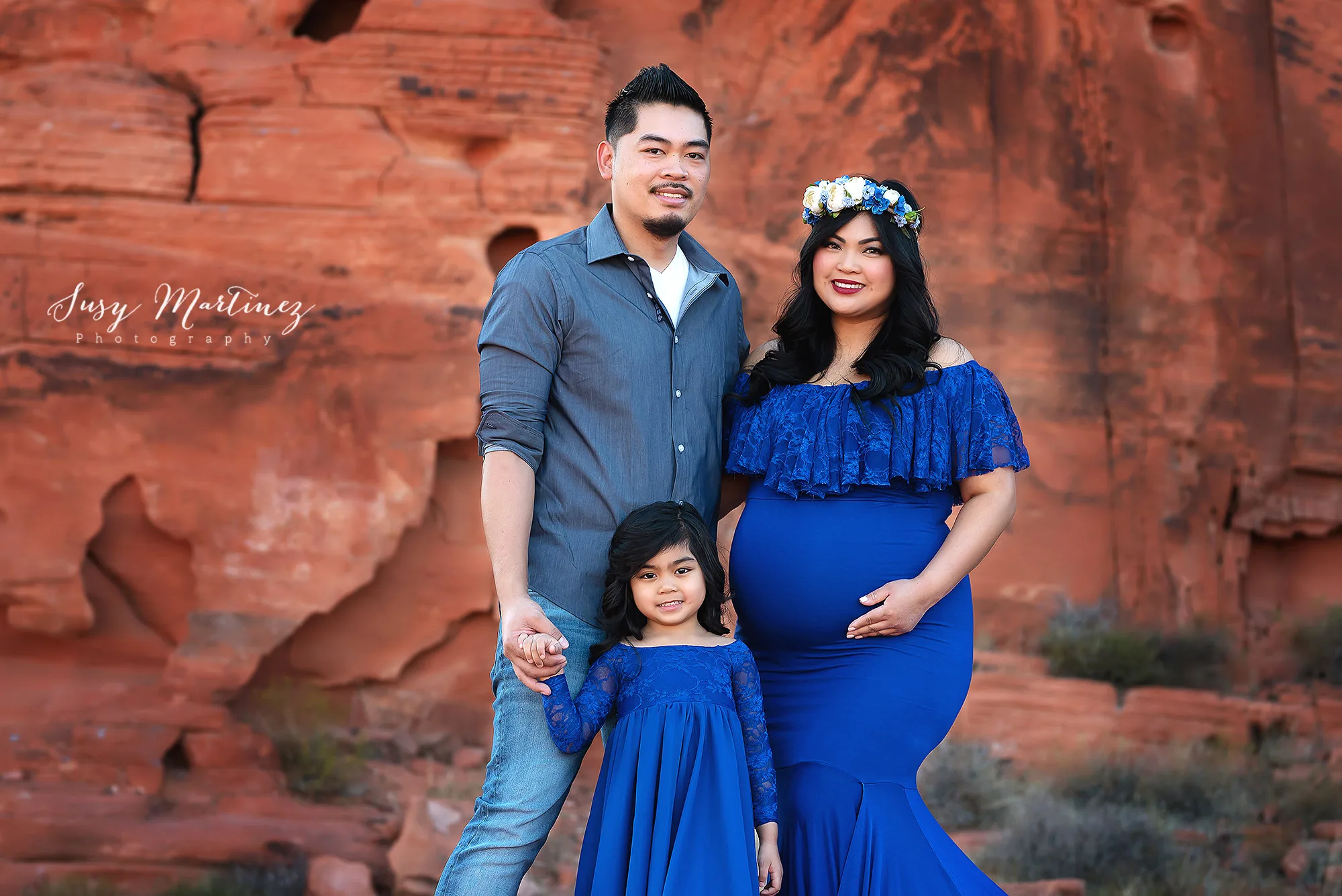 family of three poses in Valley of Fire during maternity photos