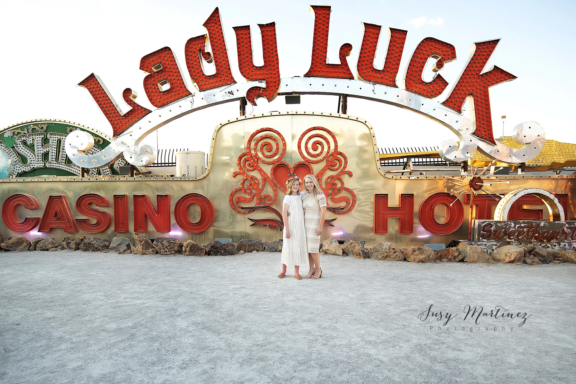 mom and daughter pose in front of red and gold sign in Nevada