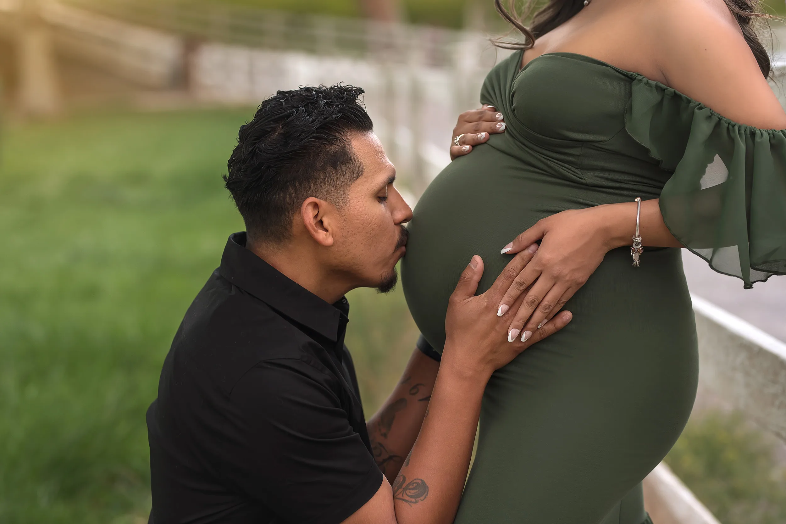 man kisses mom's belly during Spring Mountain Ranch Maternity Session