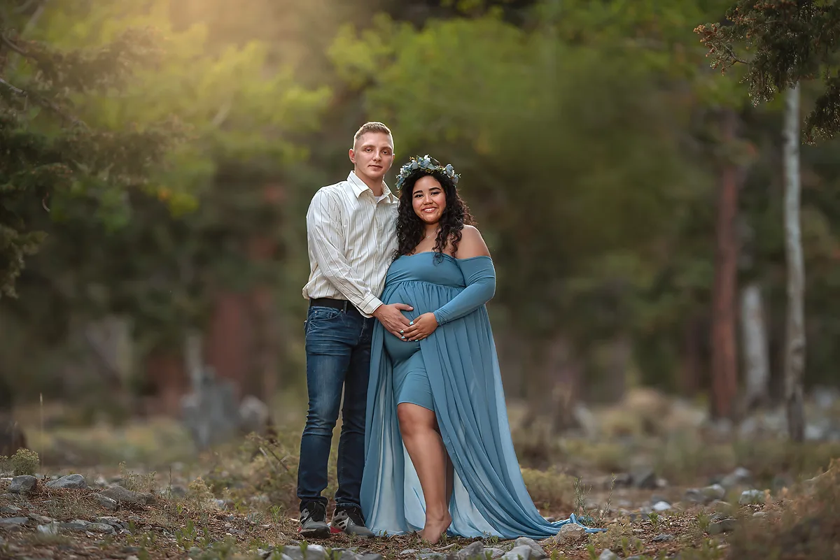 expecting parents stand on mountaintop in Las Vegas holding mom's bump 