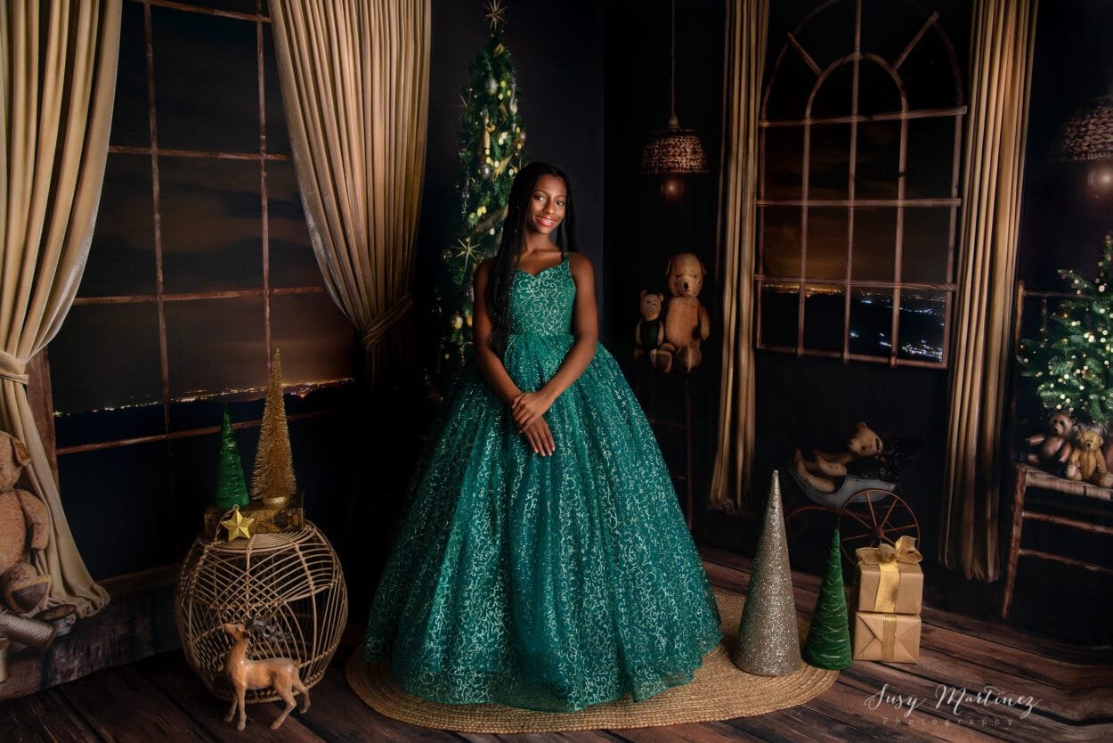 girl in a gorgeous green couture gown in a golden holiday living room